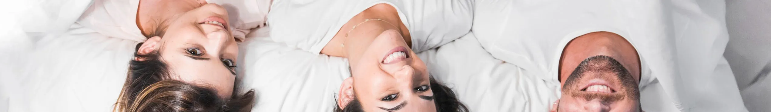 Tre persone distese su un letto